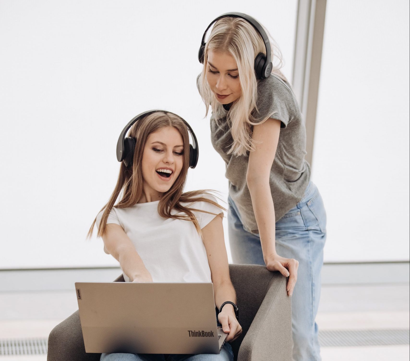 Two girls smiling with laptop and earphones
